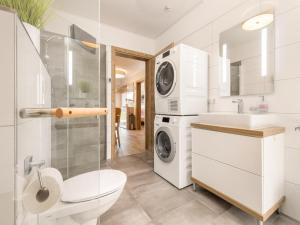 a bathroom with a sink and a washing machine at Chalet Alpenzauber mit beheiztem Pool, Inzell in Inzell +44 photos