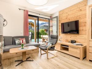 a living room with a couch and a tv at Chalet Alpenzauber mit beheiztem Pool, Inzell in Inzell