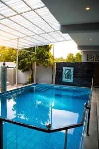 a swimming pool with blue water in a building at Aquora Pool Stays in Pondicherry