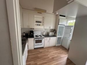 a kitchen with white appliances and a wooden floor at Apartment in Skellefteå