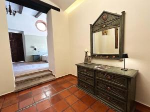 a bathroom with a dresser and a mirror on the wall at Hacienda Casa Grande, suite esmeralda in Guadalajara