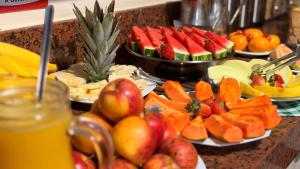 a buffet of fruits and vegetables on plates on a counter at Domus Hotel Cidade Nobre - Ipatinga in Ipatinga