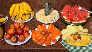 a bunch of plates of fruit on a table at Domus Hotel Cidade Nobre - Ipatinga in Ipatinga