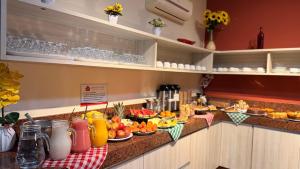 a buffet line with fruits and drinks on a counter at Domus Hotel Cidade Nobre - Ipatinga in Ipatinga