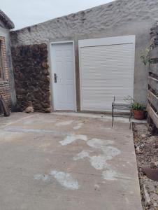 a garage with a white door and a bench at Estancia serena in Guichón