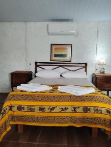 a bedroom with a large bed with a yellow blanket at Estancia serena in Guichón