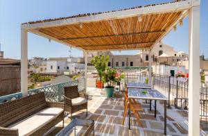 a deck with a wooden pergola and tables and chairs at B&B Corso Garibaldi in Otranto