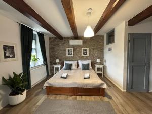 a bedroom with a bed and a brick wall at Vitamin K73 Vendégház in Boldogkőváralja