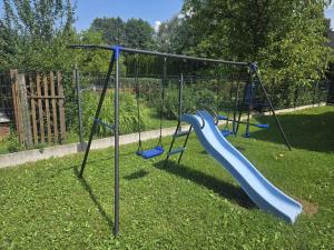 a playground with a blue slide in the grass at Wilkowiana in Wilkowice