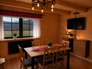 a dining room with a wooden table and chairs at Wilkowiana in Wilkowice