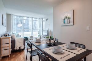 a living room with a dining room table with chairs at Victoria Suites - Downtown in Toronto