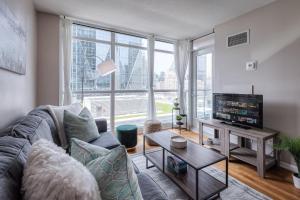 a living room with a couch and a tv at Victoria Suites - Downtown in Toronto
