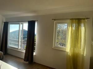 a room with two large windows with curtains at Desa's place in Babino Polje +3 photos