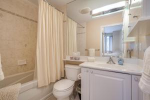 a bathroom with a toilet and a sink and a tub at Victoria Suites - Downtown in Toronto