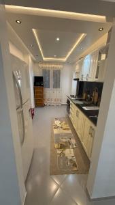 a kitchen with a white refrigerator and a sink at Rèsidance Mimosa in Bejaïa