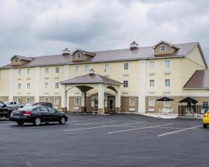 a large building with cars parked in a parking lot at Jonestown Inn in Jonestown