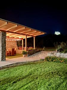 a pavilion with a table and chairs at night at Vitamin K73 Vendégház in Boldogkőváralja