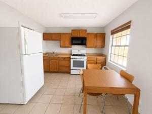 a kitchen with a table and a white refrigerator at Silver Queen Inn in Kingman