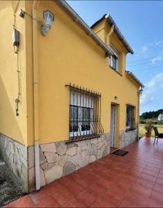 a yellow house with a fence on the side of it at El polvorín in El Franco