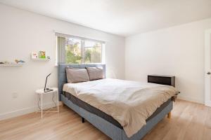 a bedroom with a large bed and a window at Serene Garden Suite in Delta
