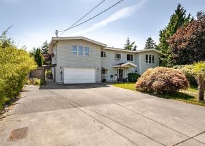 a large white house with a driveway at Serene Garden Suite in Delta