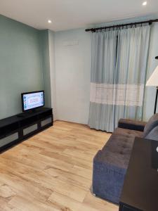a living room with a couch and a flat screen tv at Civico 32 in Mondovì