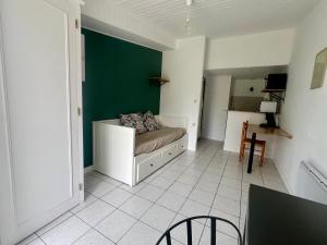a room with a couch and a green wall at Chez Laurie et Xavier studio 3 in Mignaloux-Beauvoir