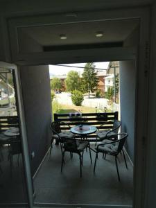 a patio with a table and chairs on a balcony at Sokak Apartman in Bihać