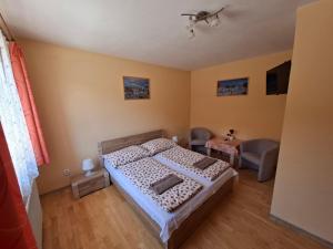 a bedroom with a bed and a table and a tv at Pension Chalupka ll with a panoramic view of Spiš Castle in Spišské Podhradie