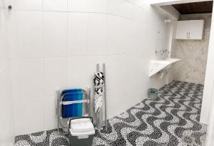 a bathroom with a black and white floor and a toilet at G2 Hospedagem Suites & Studio Praia Dos Anjos in Arraial do Cabo