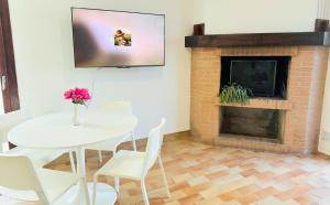 a living room with a table and a fireplace at Ciconi Garden Studio Apartment in Gorizia
