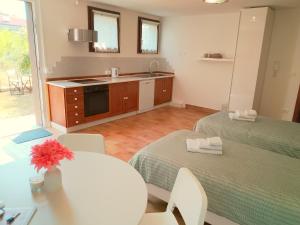a kitchen with two beds and a sink and a table at Ciconi Garden Studio Apartment in Gorizia