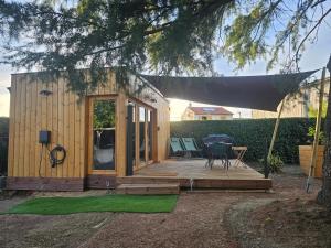 a small shed with a table and chairs on a deck at L'Escapade du Puy in Saint-Amand-sur-Sèvre
