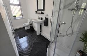 a bathroom with a toilet and a sink and a shower at Northenden Stayzzz in Manchester