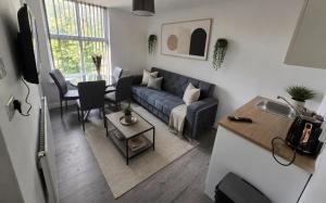 a living room with a couch and a table at Northenden Stayzzz in Manchester