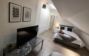 a bedroom with a bed and a fireplace in a room at Northenden Stayzzz in Manchester