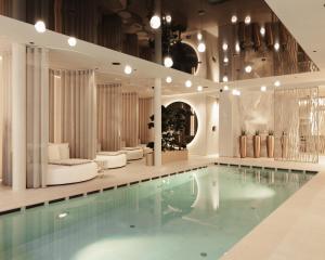 a pool in a hotel room with white furniture at My Mountain Moments - Adults Only 12 plus in Selva dei Molini