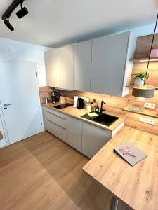 a kitchen with white cabinets and a wooden counter top at Inselliebe Norderney in Norderney