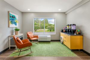 a office with two chairs and a desk and a window at Spark By Hilton Freeport in Freeport