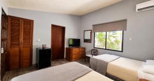 ein Hotelzimmer mit zwei Betten und einem Fernseher in der Unterkunft Sina Suites Cancun - Adults Only in Cancún + 34 Fotos