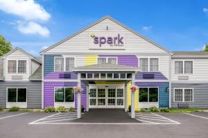 a brightly colored spartan building with a parking lot at Spark By Hilton Freeport in Freeport