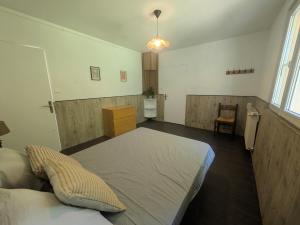 a bedroom with a large bed and a kitchen at Le Petit Gîte de L'Étang in Saint-Géry