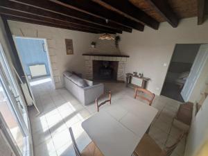a living room with a couch and a table and a fireplace at Le Petit Gîte de L'Étang in Saint-Géry