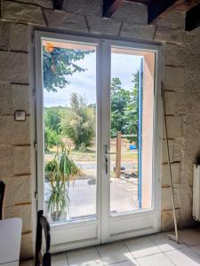 an open door with a view of a yard at Le Petit Gîte de L'Étang in Saint-Géry