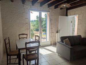 a living room with a table and chairs and a couch at Le Petit Gîte de L'Étang in Saint-Géry