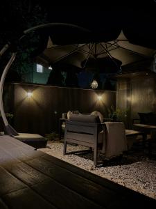 a patio with a couch and an umbrella at night at Beta House Apartments in Zaječar