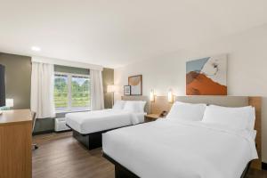 a hotel room with two beds and a window at Spark By Hilton Freeport in Freeport