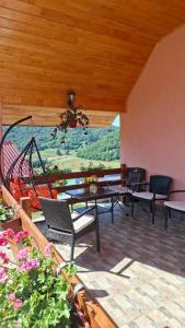 a patio with tables and chairs and a large window at Nature House in Pljevlja