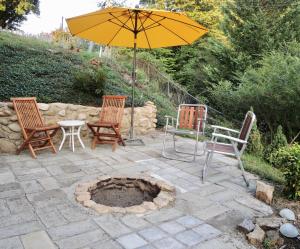 a patio with chairs and an umbrella and a fire pit at Charming Roanoke Guesthouse in Roanoke