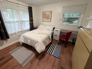 a small bedroom with a bed and a red chair at Charming Roanoke Guesthouse in Roanoke